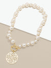 Zenzii Ornate Pendant Chunky Pearl Necklace laying flat on two-tone display
