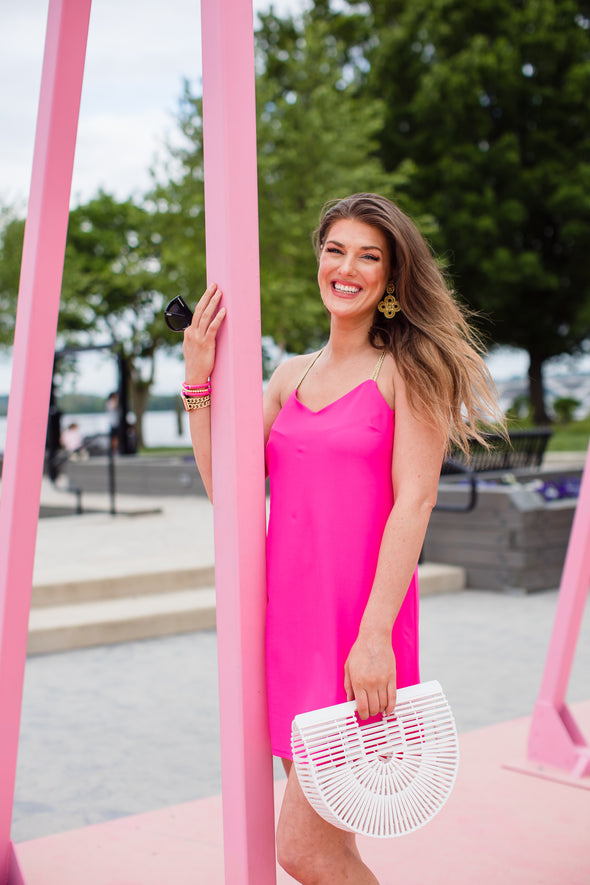 Model wearing Jude Connally Bailey Dress in Spring Pink with white bamboo purse