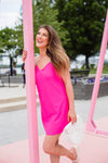 Model outside wearing Jude Connally Bailey Dress in Spring Pink with White bamboo purse