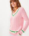 Side view of the Lilly Pulitzer Brockton Sweater. A light pink varsity style sweater with green accent stripes around the v neck collar, wrists, and bottom hem