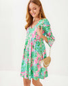 Smiling model in the Lilly Pulitzer Jannie V-Neck 3/4 Sleeve Dress - Multi - Plumes In Bloom with rattan purse 