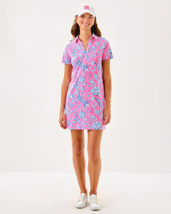 Full view of smiling model in the Lilly Pulitzer Dune Short Sleeve Dress - Rousseau Pink - Barefoot Beachcombers. A hot pink mini dress with short sleeves and a collar, with light blue beach motifs 