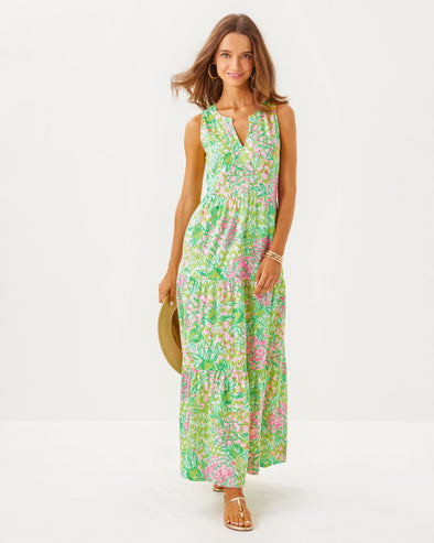 Smiling model in the Lilly Pulitzer Sydnee Maxi Dress - Fauna Green - Lime Feeling Good. A sleeveless maxi dress with a notched neckline in beautiful green and pink pattern