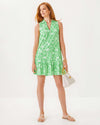 Full body view of the Model in the Lilly Pulitzer Riegan Dress - Fauna Green. A sleeveless mini dress with a mock neck and ruffle at the bottom hem, in a green floral pattern 