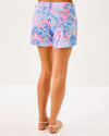 Smiling model in the Lilly Pulitzer Callahan Stretch Short - Elephant Splash. Light blue shorts with pink, blue, yellow, and purple details 