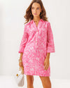 Model in the Lilly Pulitzer Daphnie Tunic Dress - Rousseau Pink - Tulip To Tango Enginee. A 3/4 sleeve mini dress with a collar and v neck with button closure 