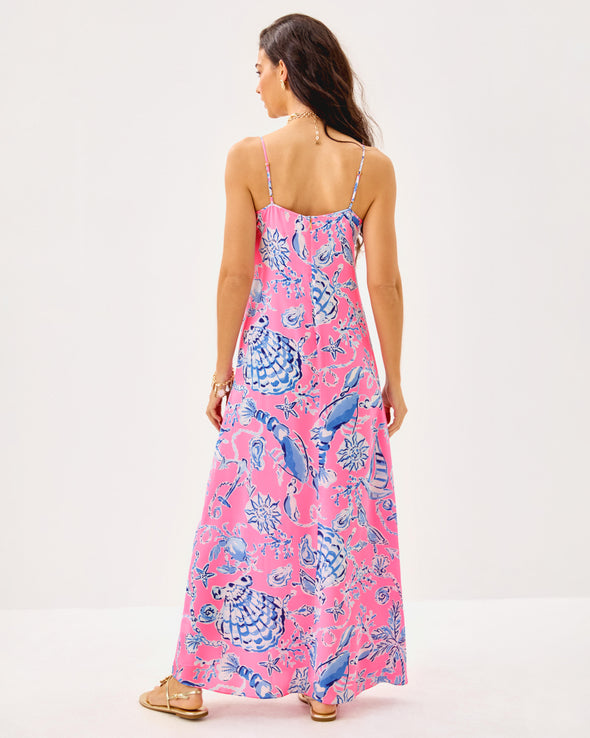 Back view model in the Lilly Pulitzer Verica Silk Maxi Dress - Rousseau Pink - Oversized Barefoot Beachcombers. A spaghetti strap, hot pink maxi dress with blue shell details 