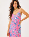 Smiling model in the Lilly Pulitzer Verica Silk Maxi Dress - Rousseau Pink - Oversized Barefoot Beachcombers. A spaghetti strap, hot pink maxi dress with blue shell details 