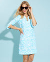 Smiling model in sunglasses wearing the Jude Connally Megan Dress - Painted Tile Aqua with sunglasses and gold bracelets 