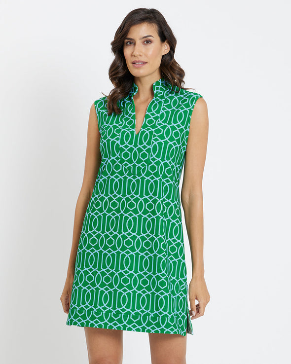 Brunette woman wearing a geometric print sleeveless green dress