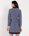 Woman wearing a blue and white striped dress on a plain background
