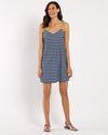 Smiling model in a navy and white striped mini dress with gold straps
