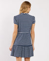 Woman wearing a navy and white striped dress on a plain background