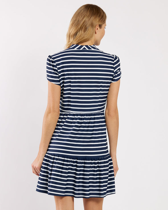 Woman wearing a navy and white striped dress on a plain background