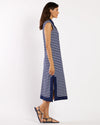 Woman wearing a navy and white striped dress on a white background