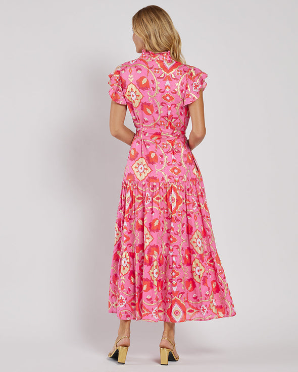 Back view of the Jude Connally Mirabella Dress in Gilded Garden Peony Pink Gold. A pink orange and gold midi dress with flutter sleeves and tie belt with a floral/geometric pattern