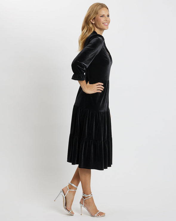 Side view of model wearing Jude Connally Maggie Velvet Midi Dress in Black with white background