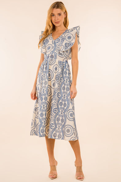 Full body view of model in the Providence Eyelet Midi Dress. A midi length dress with blue eyelet detailing, with puffy sleeves and a zip closure