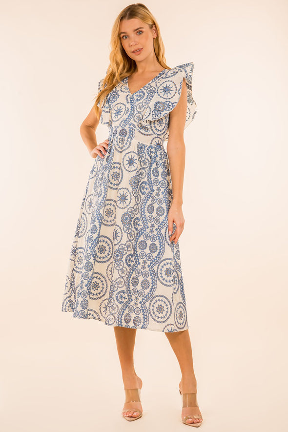 Full body view of model with hand on hip in the Providence Eyelet Midi Dress. A midi length dress with blue eyelet detailing, with puffy sleeves and a zip closure