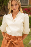 Model outside wearing the Voy Sloane Puff Sleeve Top in Cream