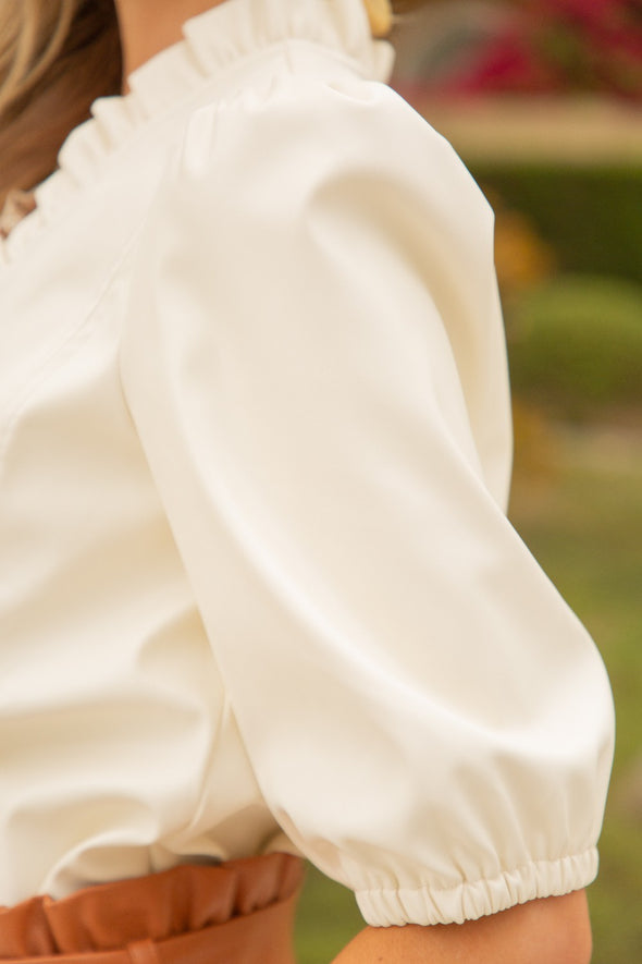Close up of cream, vegan leather puff sleeve