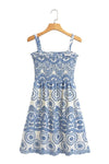 Back view of smocked blue and white eyelet dress on hanger