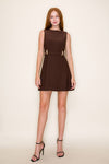 Model in a sleeveless brown dress with a boatneck neckline a belt with gold detailing