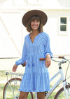 Model leaning against a bike in the Cabana Life Sullivans Island Tiered Ruffle Dress