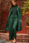 Model in a green knee length suede jacket with matching green suede trousers