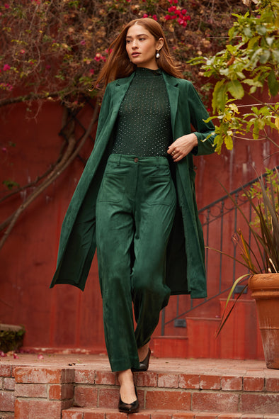 Woman in a knee length green suede jacket 