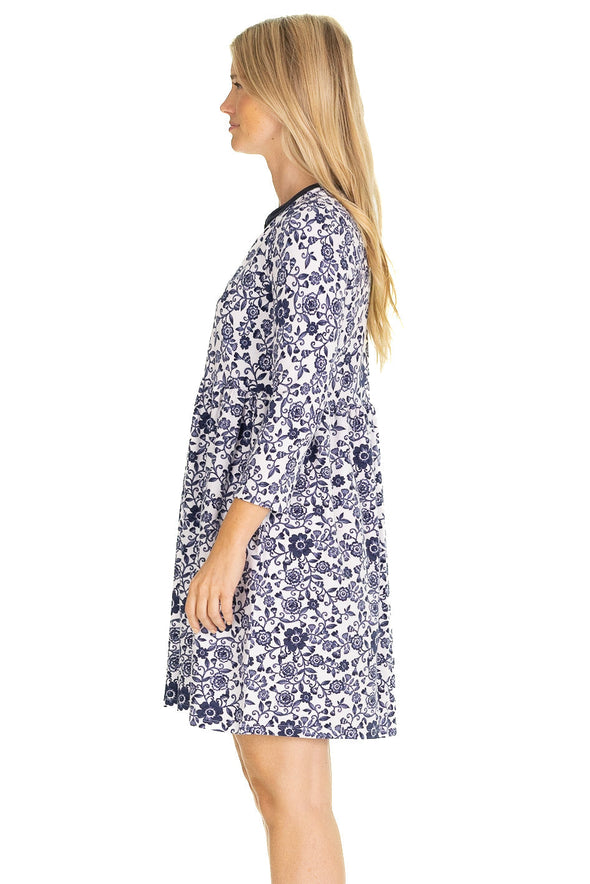 Side view of model in a mini length, 3/4 sleeve dress with a navy floral pattern on a white background