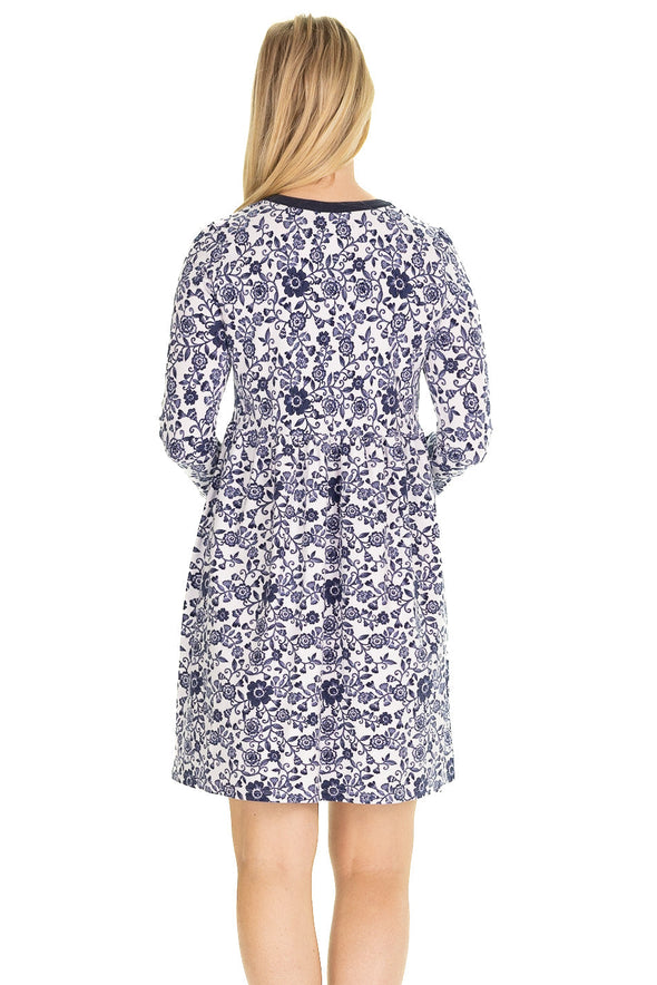 Back view of model in a mini length, 3/4 sleeve dress with a navy floral pattern on a white background