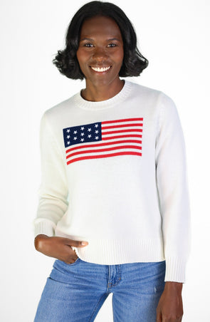Woman In a white sweater with an American flag and jeans