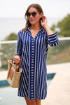 Model in the Duffield Lane Oaklee Dress - Navy/ White Stripe with a woven bag