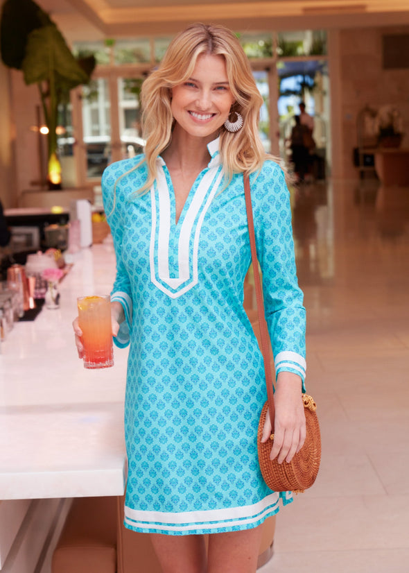 Smiling model with a drink in hand in the Cabana Life Amalfi Coast Long Sleeve Tunic Dress
