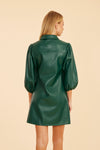 Back view of the model wearing the Dolce Cabo Soft Vegan Leather Dress in Forest Green. A mini shift silhouette with soft faux leather, 3/4 puff sleeves, and front button detailing