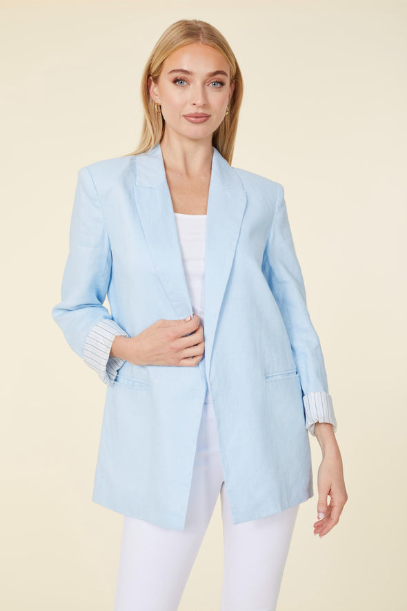 Model in a light blue linen blazer. Stripped lining that shows when cuffed