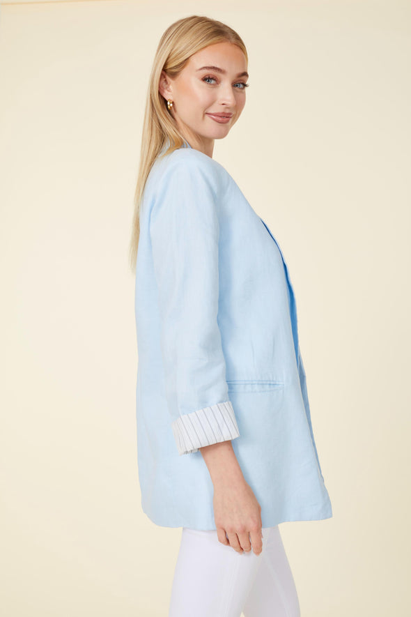 Model in a light blue linen blazer. Stripped lining that shows when cuffed