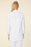Back view of model in white linen blazer and white pants
