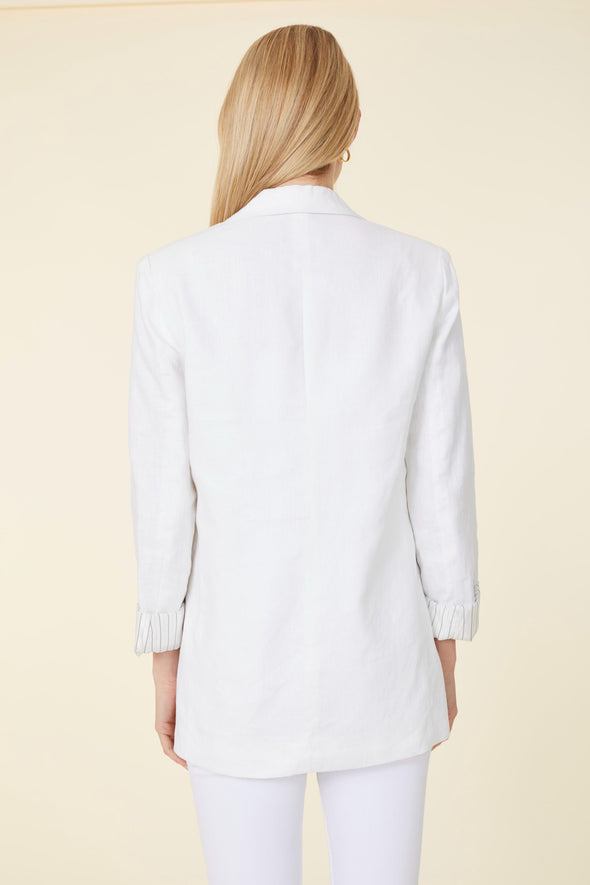 Back view of model in white linen blazer and white pants