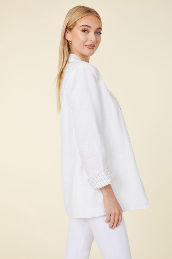 Side view of model in a white linen blazer and white pants