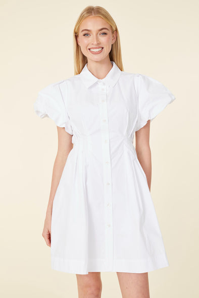 Smiling model in a short white dress with puff sleeves and buttons down the front