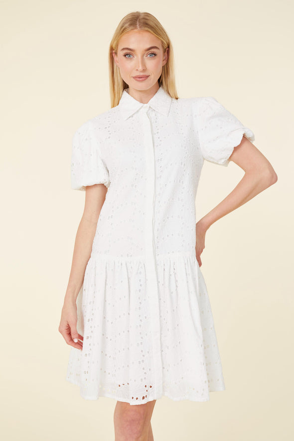 Model in a white eyelet short dress with a collar, buttons, and puff sleeves