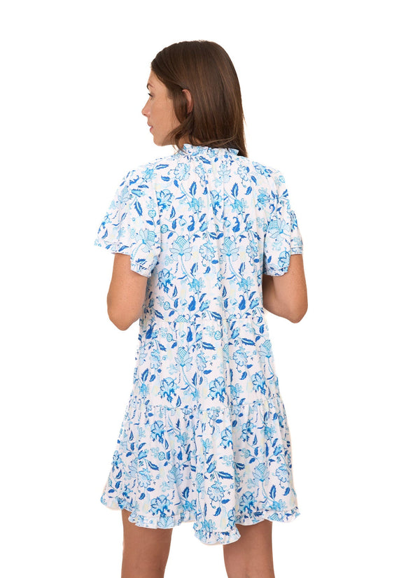 Back view of the Cabana Life Bubbly Short Sleeve Tiered Ruffle Dress. A short sleeved, tiered, v-neck dress that is white with blue floral pattern 
