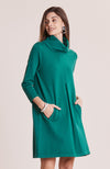 Front view of model wearing Tyler Böe Kim Cowl Dress in Verde Cotton Cashmere with hands in front pockets