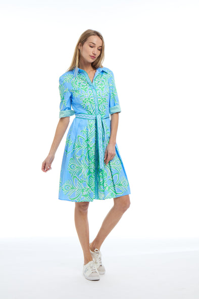 Model in blue and green, tropical print, knee length dress with a collar and tie waist
