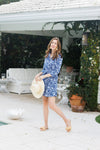Smiling model by the pool in the  Duffield Lane Camila Dress in Navy Blossoms 