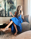 Indoor model sitting in the Duffield Lane X Lucky Knot Exclusive Duxbury Midi Dress - Bright Blue Metallic