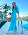 Side View of Model by Pool Wearing Teal Maxi Dress with Tiered skirt and 3/4 Sleeves