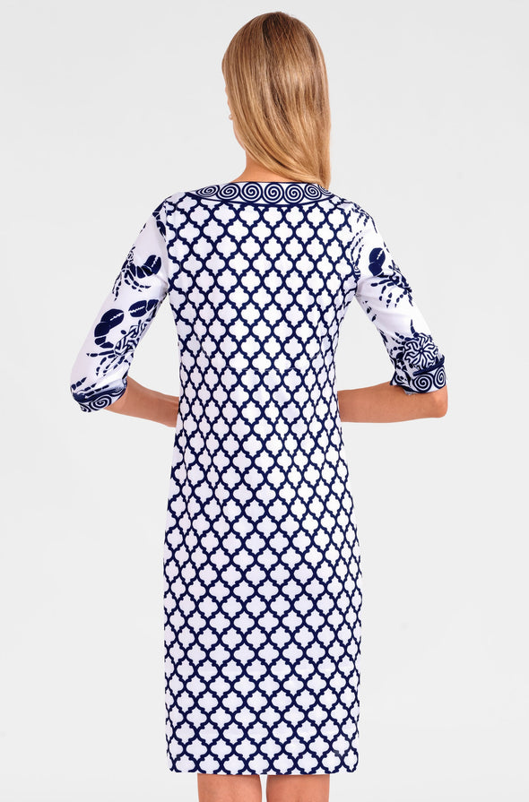Blonde woman facing away wearing navy and white geometric print 3/4 sleeve dress with contrast crab print on sleeves 